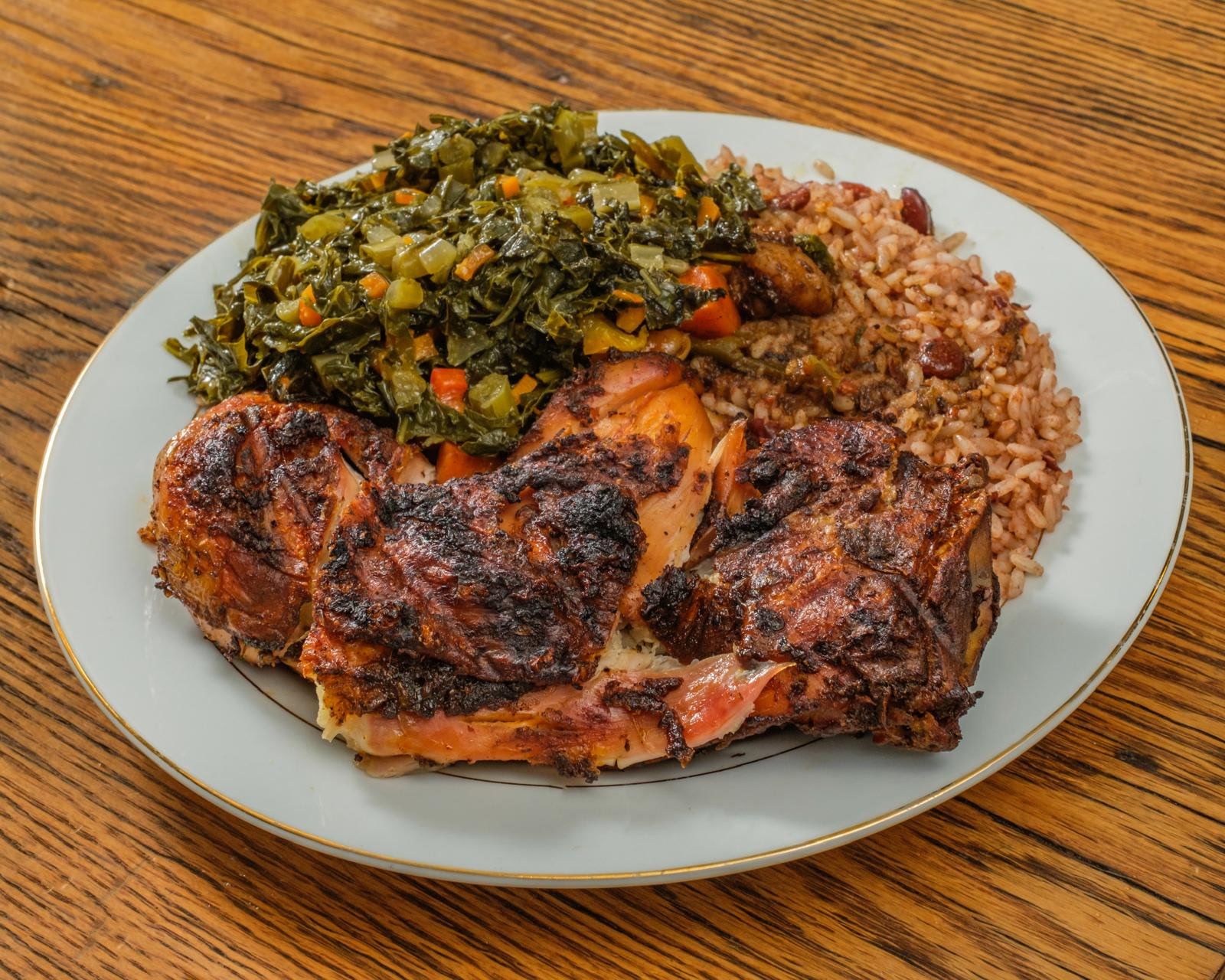 Jerk chicken with collard greens and rice and peas