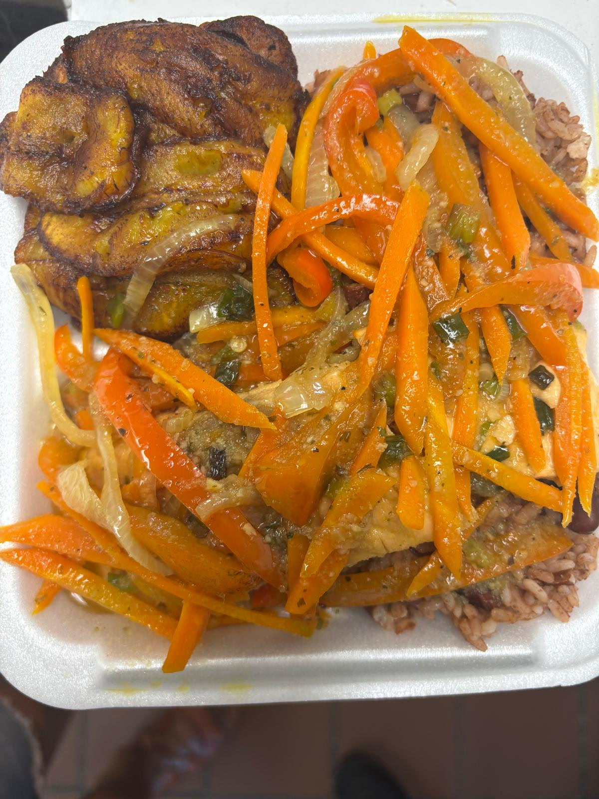 Escovitch fish with fried plantains and rice and peas